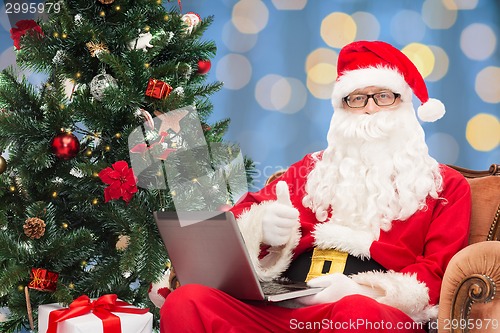 Image of man in costume of santa claus with laptop