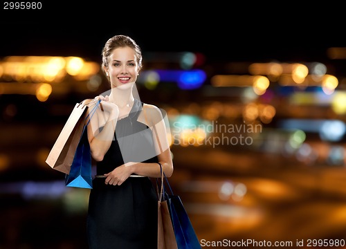 Image of smiling woman in dress with shopping bags