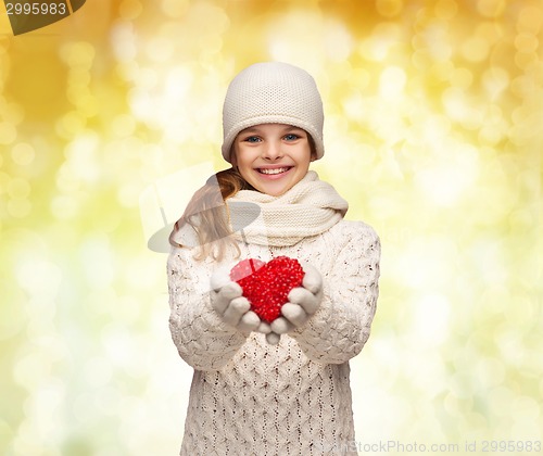 Image of dreaming girl in winter clothes with red heart