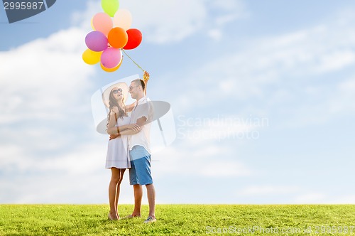 Image of smiling couple with air balloons outdoors