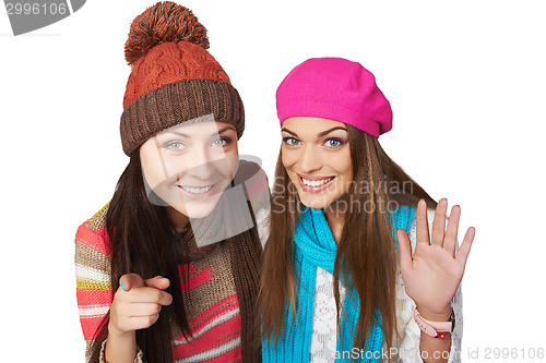 Image of Two girl peeping into camera