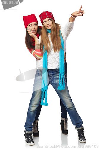 Image of Two winter woman pointing at copy space