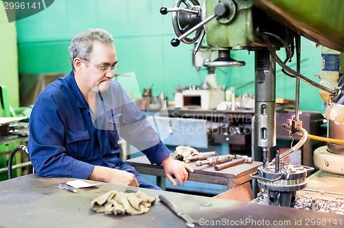 Image of Senior milling machine operator works at machine