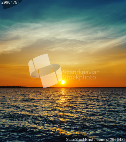 Image of orange sunset over dark water