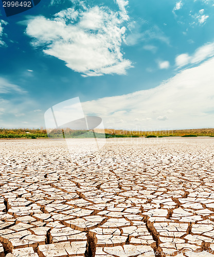 Image of dramatic sky with clouds over cracked desert