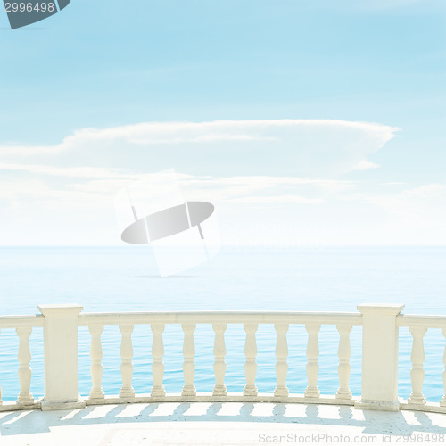 Image of balcony over sea and light clouds in blue sky