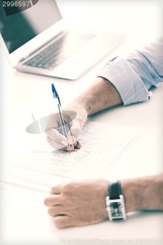 Image of man signing a contract