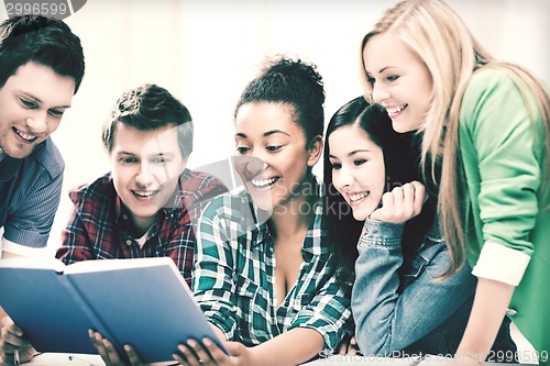 Image of students reading book at school