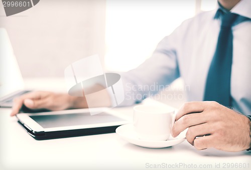 Image of businessman with tablet pc and coffee in office