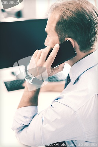 Image of businessman with smartphone in office