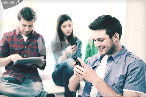 Image of student looking into smartphone at school