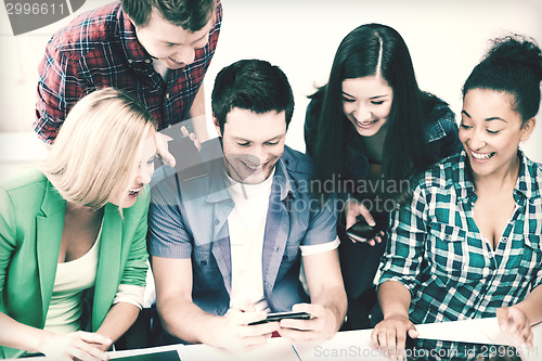 Image of students looking into smartphone at school