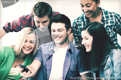 Image of students looking into smartphone at school