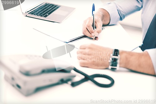 Image of businessman writing in notebook