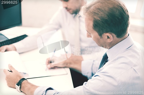 Image of businessmen with notebook on meeting