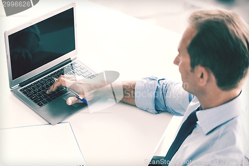 Image of miling businessman working in office