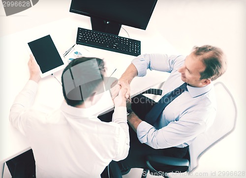 Image of businessmen shaking hands in office