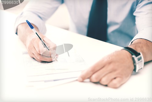 Image of man signing a contract