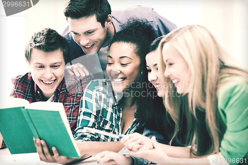 Image of students reading book at school