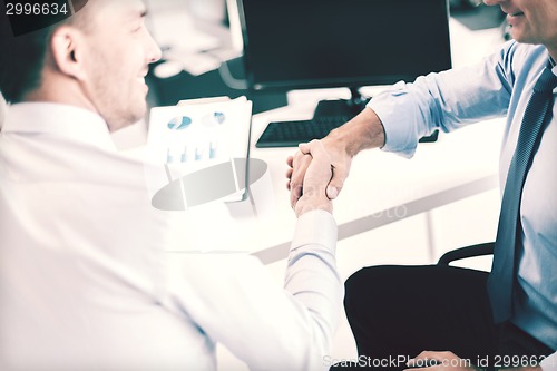 Image of businessmen shaking hands in office