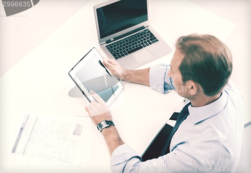 Image of businessman with tablet pc and papers in office