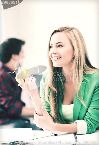 Image of student girl with green apple in college