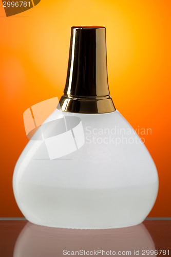 Image of White bottle stands on the mirror surface