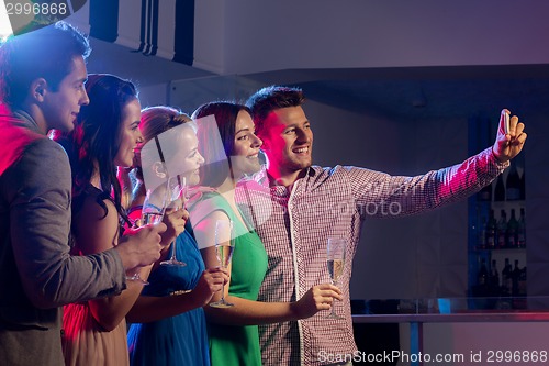 Image of friends with glasses and smartphone in club