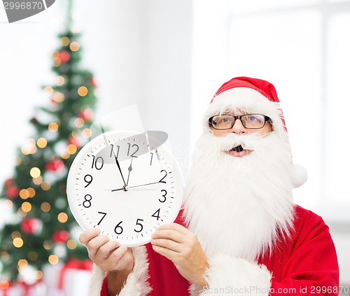 Image of man in costume of santa claus with clock