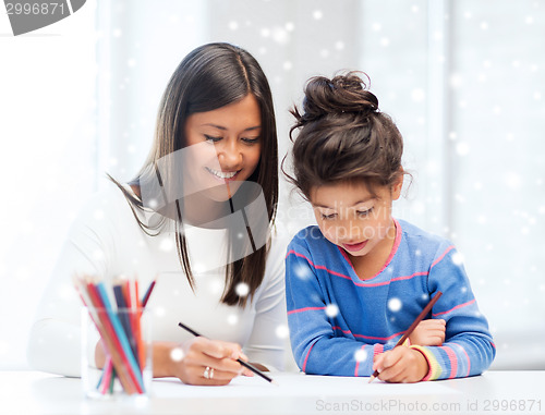 Image of mother and daughter with coloring pencils indoors