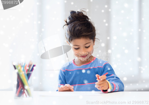 Image of smiling little girl with pencils drawing at home