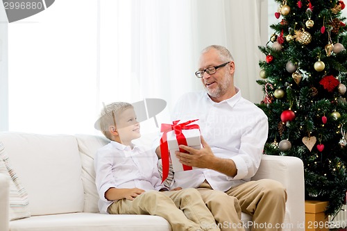 Image of smiling grandfather and grandson at home