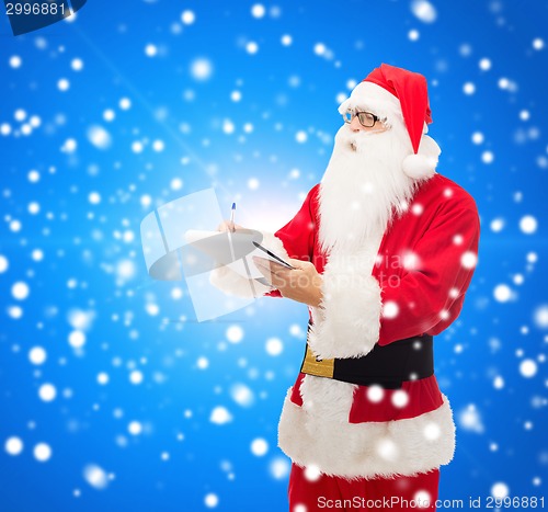 Image of man in costume of santa claus with notepad