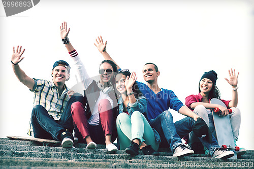 Image of group of teenagers waving hands