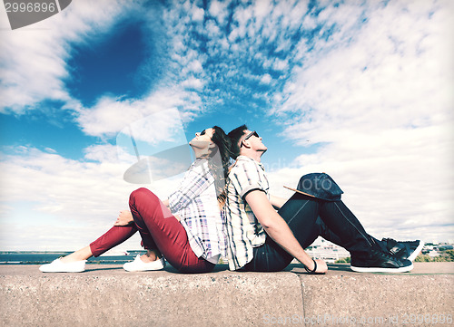 Image of teenagers sitting back to back