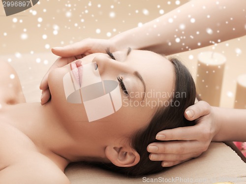 Image of beautiful woman getting face or head massage
