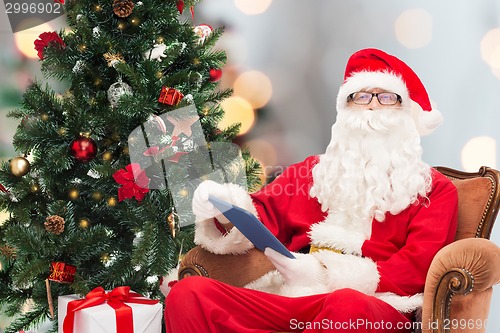 Image of man in costume of santa claus with tablet pc
