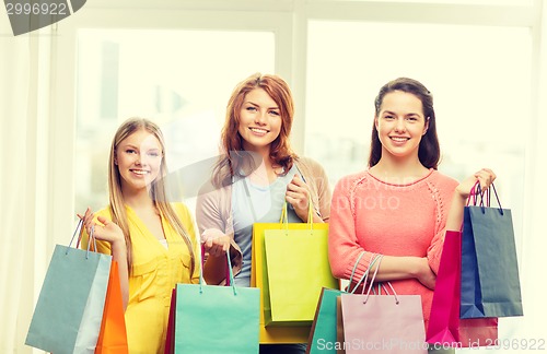 Image of smiling teenage girls with many shopping bags
