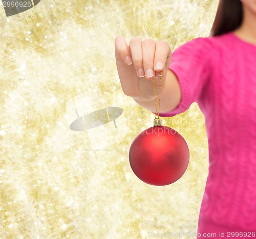 Image of close up of woman in sweater with christmas ball