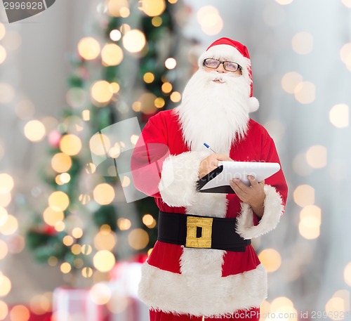 Image of man in costume of santa claus with notepad