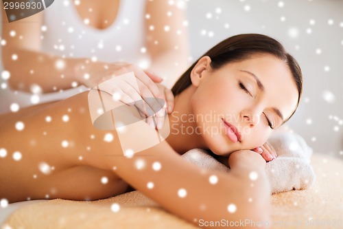 Image of beautiful young woman in spa salon getting massage