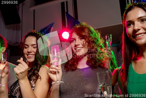 Image of smiling friends with glasses of champagne in club