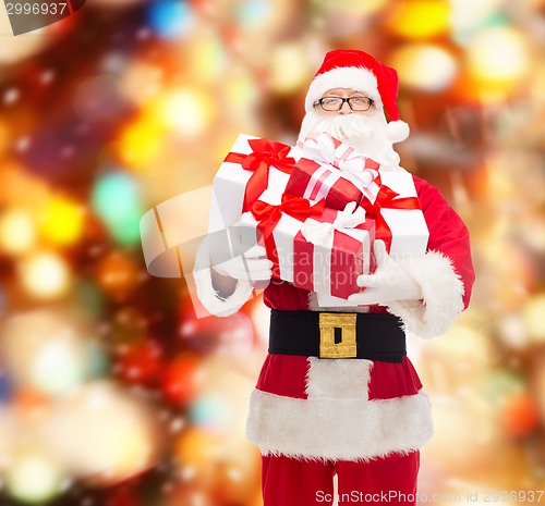 Image of man in costume of santa claus with gift boxes