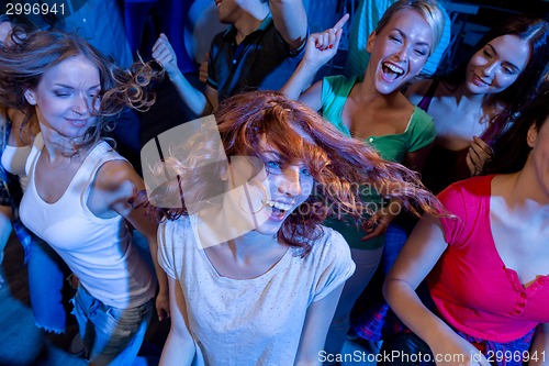 Image of smiling friends dancing in club