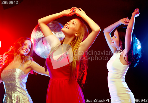 Image of three smiling women dancing in the club