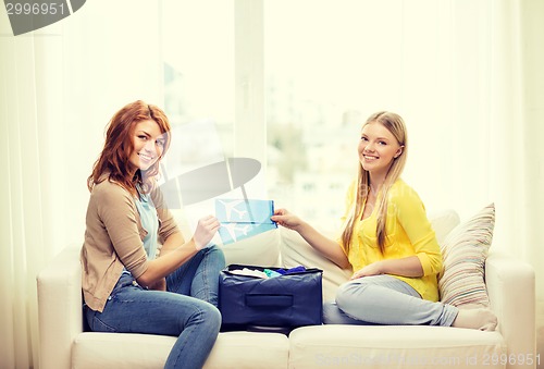 Image of two smiling teenage girls with plane tickets