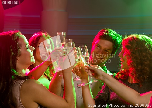 Image of smiling friends with glasses of champagne in club