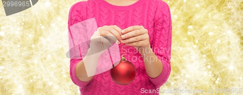 Image of close up of woman in sweater with christmas ball