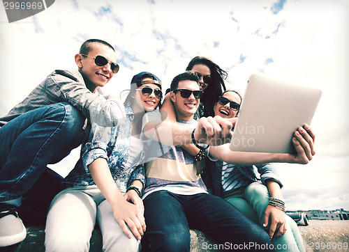 Image of group of teenagers looking at tablet pc