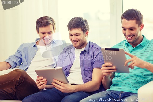 Image of smiling friends with tablet pc computers at home